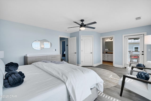 bedroom with ceiling fan, connected bathroom, wood finished floors, visible vents, and baseboards