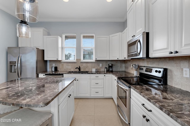 kitchen featuring stainless steel appliances, white cabinetry, and a kitchen bar