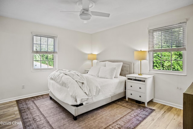 bedroom featuring multiple windows, ceiling fan, and light wood-type flooring