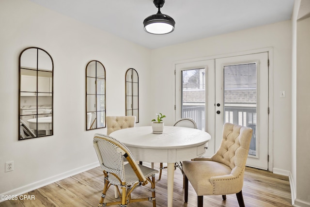 dining space featuring light hardwood / wood-style floors and french doors