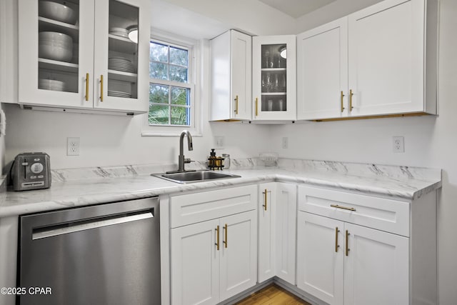 kitchen featuring sink, light hardwood / wood-style flooring, light stone counters, white cabinets, and stainless steel dishwasher