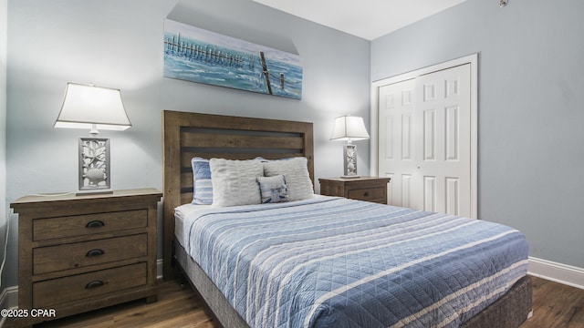 bedroom with dark wood-type flooring and a closet