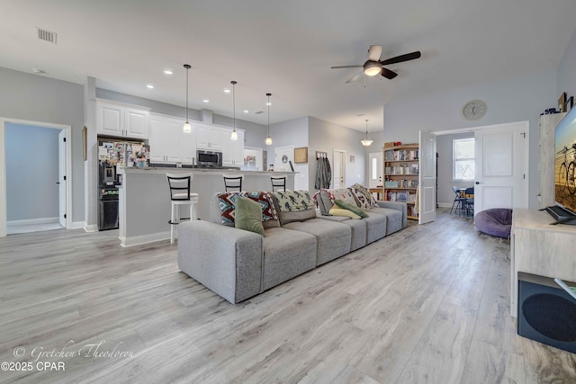 living room featuring ceiling fan and light wood-type flooring