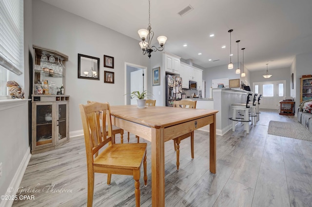 dining room with an inviting chandelier and light wood-type flooring