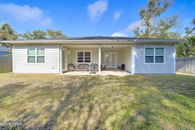 back of house featuring a lawn and a patio area