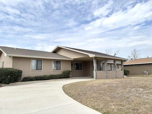 single story home with concrete driveway, central air condition unit, and stucco siding