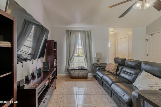 living room featuring light tile patterned flooring, baseboards, ceiling fan, and vaulted ceiling