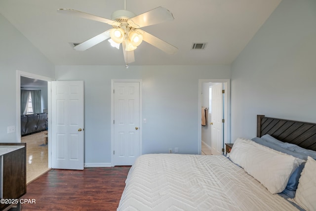 bedroom with baseboards, visible vents, lofted ceiling, dark wood-style flooring, and ceiling fan