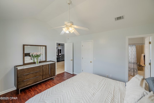 bedroom featuring visible vents, dark wood-type flooring, a ceiling fan, baseboards, and vaulted ceiling