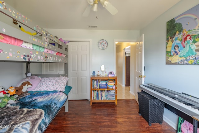 bedroom with a closet, visible vents, ceiling fan, and wood finished floors