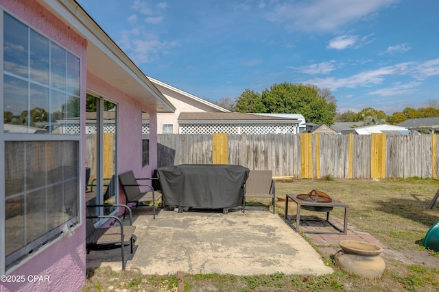 view of patio featuring grilling area, an outdoor fire pit, and fence