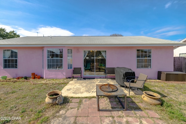 back of house with fence, stucco siding, a fire pit, central air condition unit, and a patio area