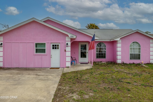 ranch-style house with a front lawn and stucco siding