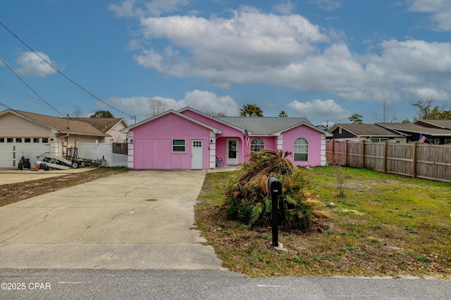 view of front facade with concrete driveway and fence