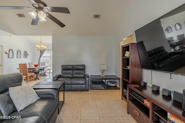 living room featuring vaulted ceiling, light tile patterned flooring, ceiling fan with notable chandelier, and visible vents