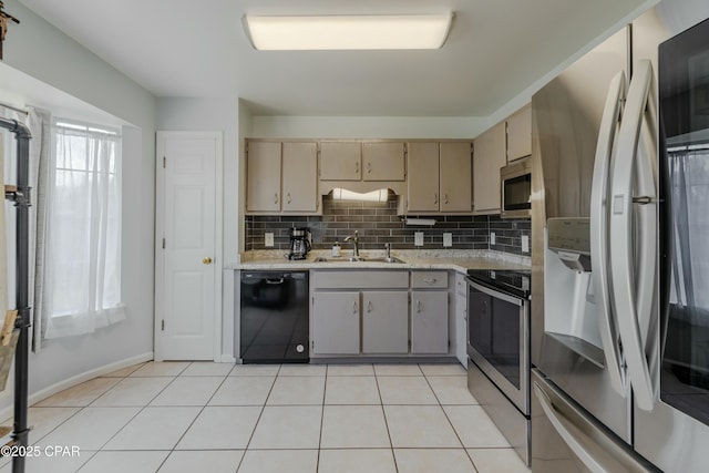 kitchen featuring light tile patterned flooring, a sink, decorative backsplash, light countertops, and stainless steel appliances