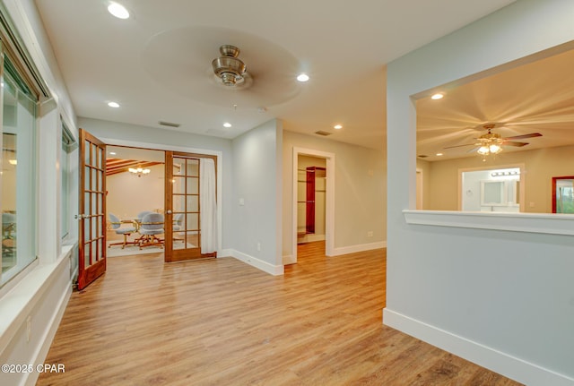 empty room with light hardwood / wood-style flooring, ceiling fan, and french doors