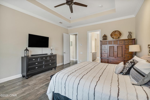 bedroom with wood finished floors, a raised ceiling, and baseboards