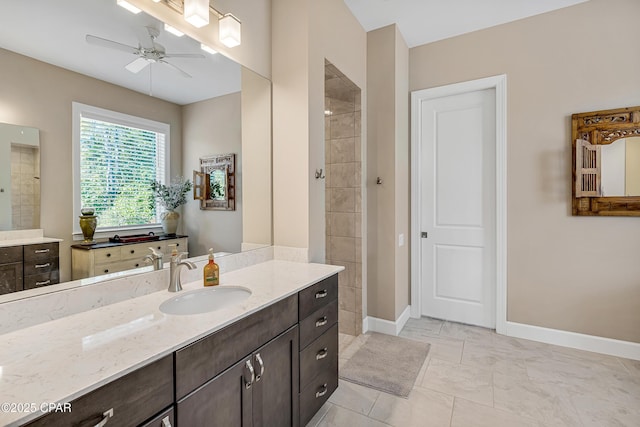 bathroom featuring ceiling fan, a tile shower, vanity, and baseboards