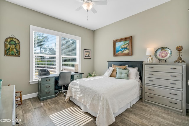 bedroom with ceiling fan, baseboards, and wood finished floors