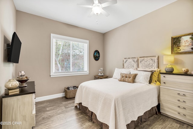 bedroom featuring ceiling fan, baseboards, and wood finished floors