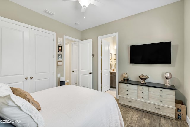 bedroom featuring visible vents, a ceiling fan, ensuite bathroom, light wood-type flooring, and a closet