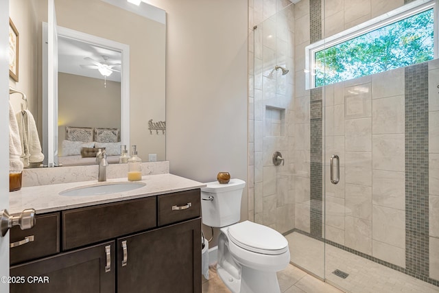 bathroom with toilet, a ceiling fan, a shower stall, ensuite bath, and vanity