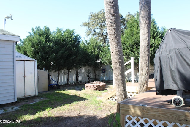 view of yard with an outbuilding, a fenced backyard, and a storage unit