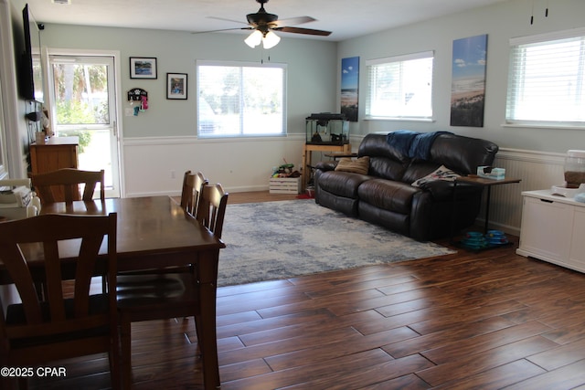 living room featuring a healthy amount of sunlight, a wainscoted wall, and wood finished floors