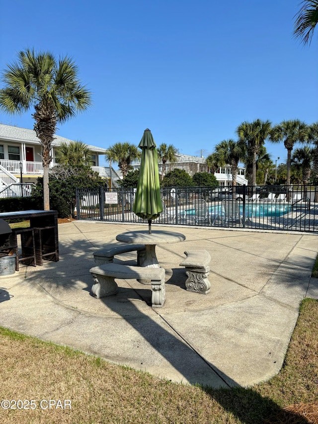 view of community featuring a patio area, fence, and a pool