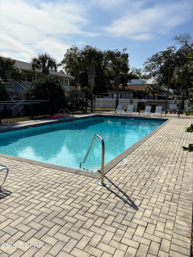 community pool with fence and a patio