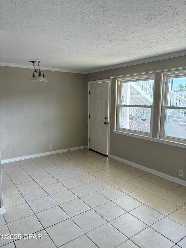 entrance foyer with baseboards, ornamental molding, a textured ceiling, a notable chandelier, and light tile patterned flooring