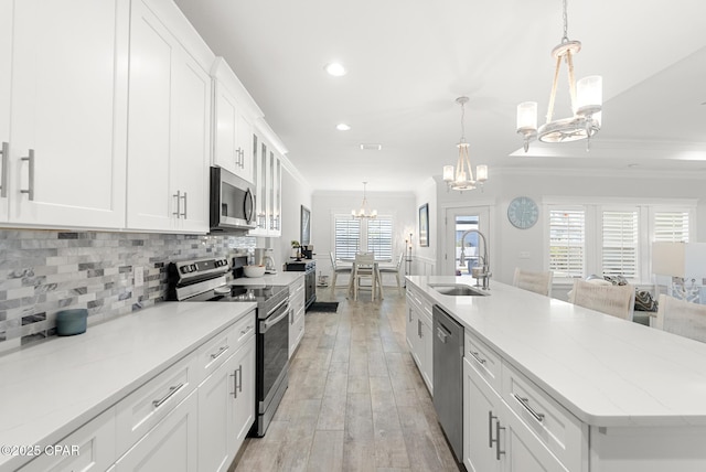 kitchen featuring sink, white cabinets, a chandelier, and appliances with stainless steel finishes