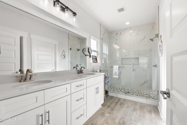 bathroom featuring vanity, an enclosed shower, and wood-type flooring