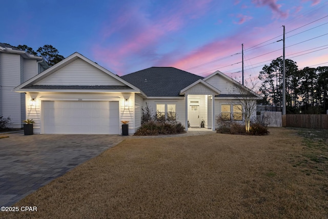 view of front of home with a garage and a lawn