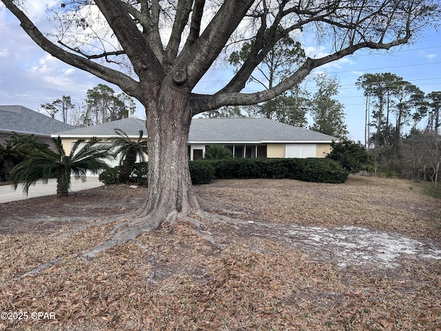 view of side of property with roof with shingles