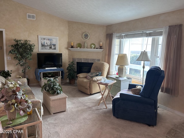 living area featuring carpet, baseboards, vaulted ceiling, visible vents, and a tile fireplace