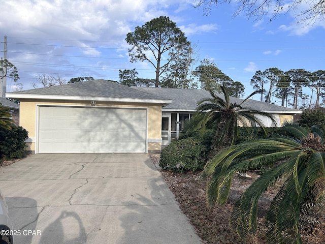 single story home featuring an attached garage, a shingled roof, driveway, and stucco siding