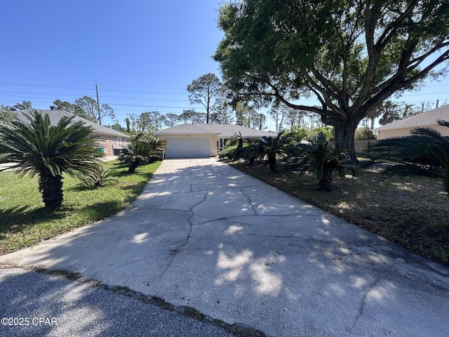 view of front of property featuring a garage, driveway, and fence