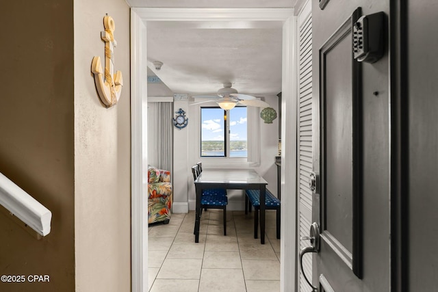 interior space with a ceiling fan and light tile patterned flooring