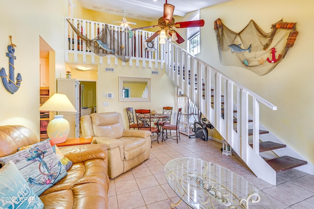 living room featuring light tile patterned flooring, a towering ceiling, and ceiling fan