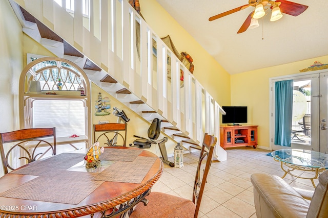 tiled dining room with ceiling fan, high vaulted ceiling, and french doors