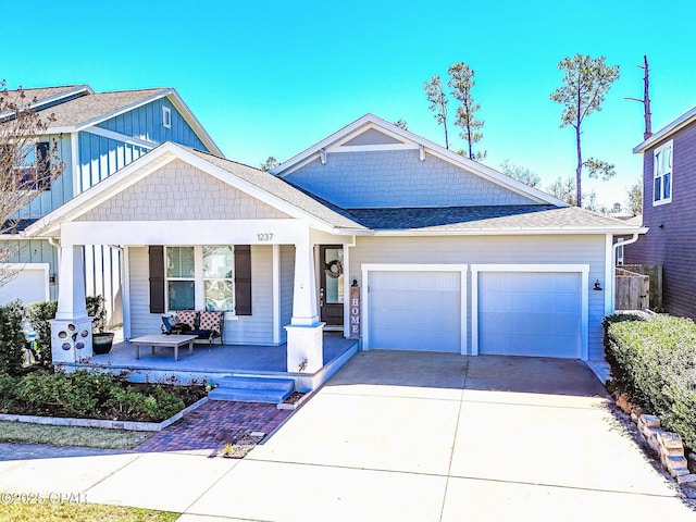 craftsman-style home with a porch, concrete driveway, and a garage