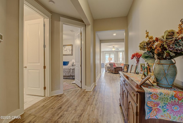 corridor featuring baseboards and light wood-style floors