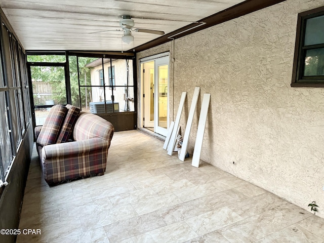 unfurnished sunroom featuring ceiling fan