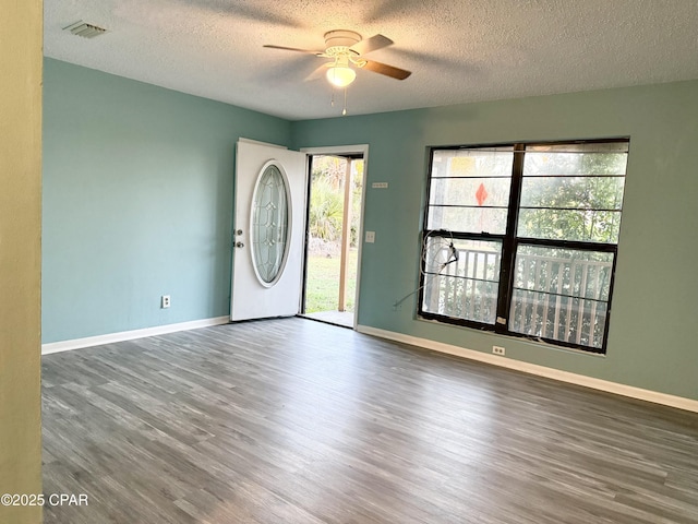 entryway featuring a textured ceiling, dark wood-type flooring, and ceiling fan