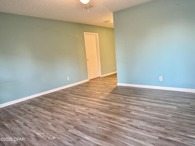 unfurnished room featuring hardwood / wood-style flooring and a textured ceiling