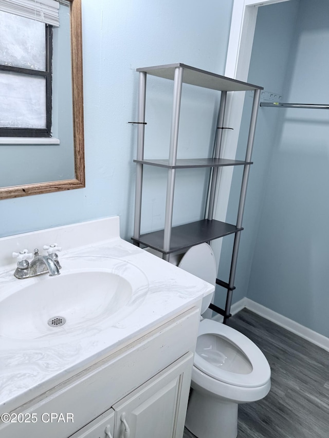 bathroom featuring vanity, hardwood / wood-style flooring, and toilet