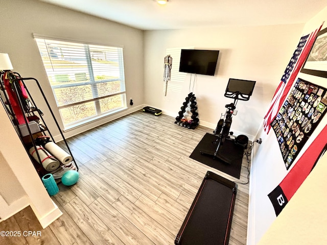 workout room with baseboards and wood finished floors