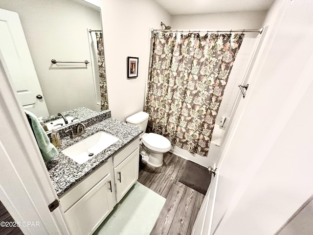 full bathroom with toilet, shower / bath combo with shower curtain, wood finished floors, and vanity